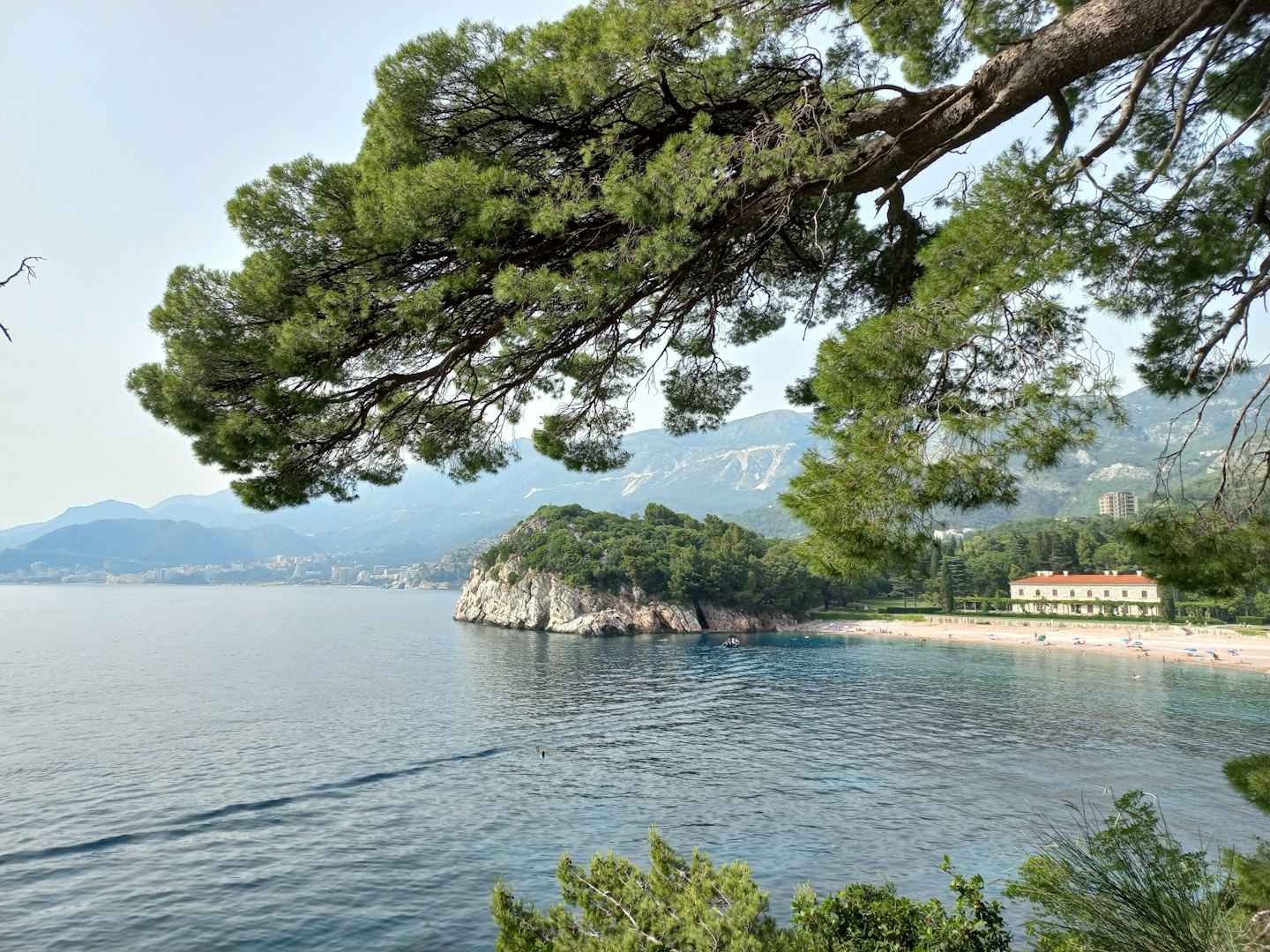 Una villa bianca con tetto arancione si affaccia su una spiaggia.